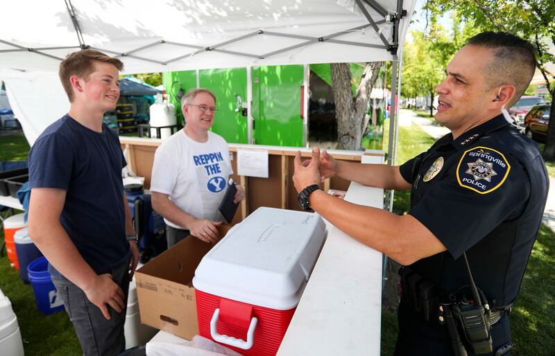 Springville Police Chief Craig Martinez talks with Richard James and his son, Wesley, at their tostada stand at Art City Days in Springville on Wednesday, June 5, 2019.