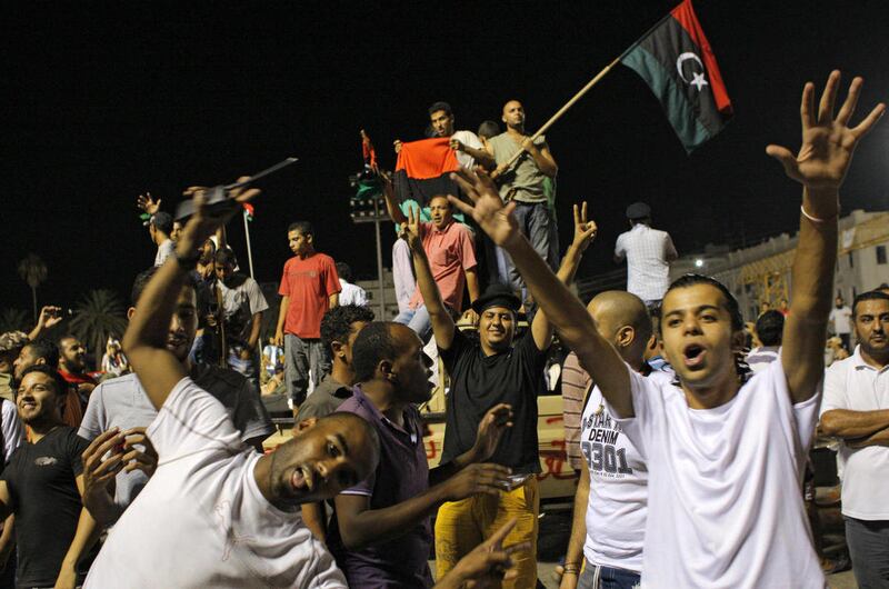 Libyans celebrate overrunning Moammar Gadhafi's compound in Tripoli, Libya, early Wednesday, Aug. 24, 2011. Hundreds of Libyan rebels stormed Gadhafi's compound Bab al-Aziziya Tuesday, charging wildly through the symbolic heart of the crumbling regime as