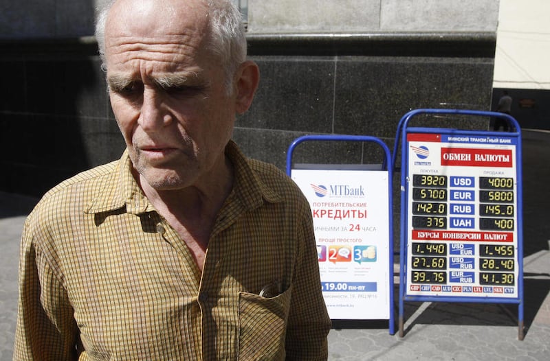 En elderly man reacts as he stands near to the currency rate notice board for the Belarusian ruble in Minsk, Belarus, Wednesday, May 11, 2011. The exchange rate of the national currency of cash-strapped Belarus has plunged by 30 percent after the governm