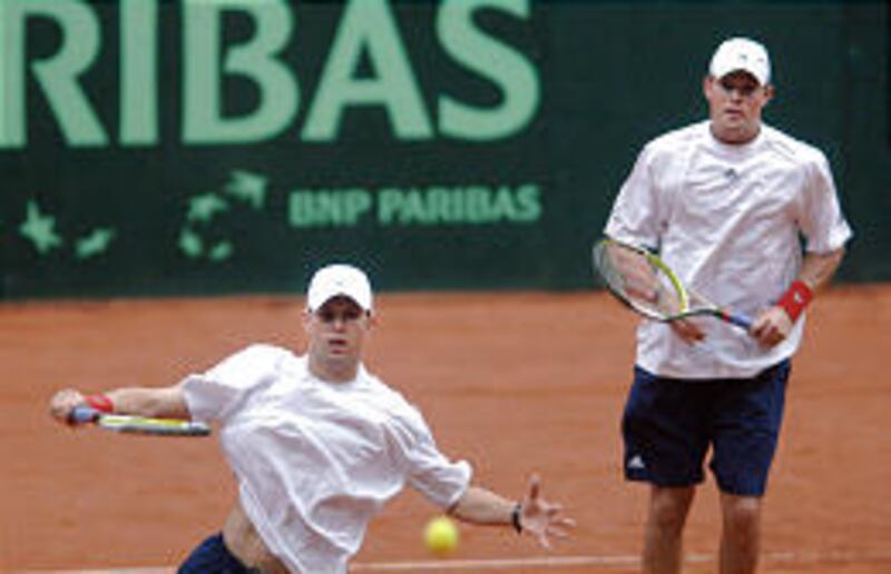 American Bob Bryan, right, looks at his twin brother, Mike, who hits a volley during their 2007 Davis Cup match against Czech's Lukas Dlouhy and Pavel Vizner. The Bryans prevailed, 6-4, 6-4, 6-4.