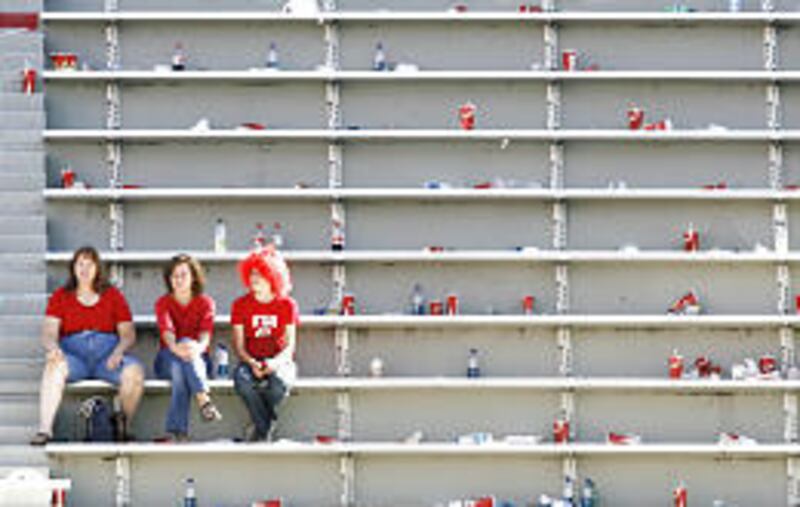 Three faithful Utah fans watch the last minutes of the Utes' drubbing at the hands of Boise State Saturday at Rice-Eccles Stadium.