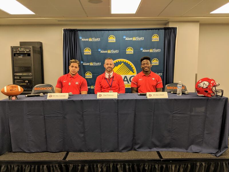 Senior running back Sei-J Lauago, left, Dixie State head football coach Paul Peterson and senior linebacker Alex Lilliard take the podium on Wednesday at the 2019 RMAC Kickoff.
