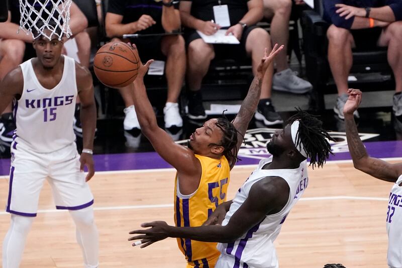 Los Angeles Lakers guard Justin Robinson, left, reaches for the ball in front of Sacramento Kings center Neemias Queta.