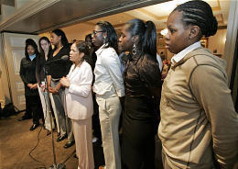 C. Vivian Stringer, center at microphone, head coach of the Rutgers women's basketball team, stands with her players as she accepts accolades for the team's second place performance in the NCAA tournament.