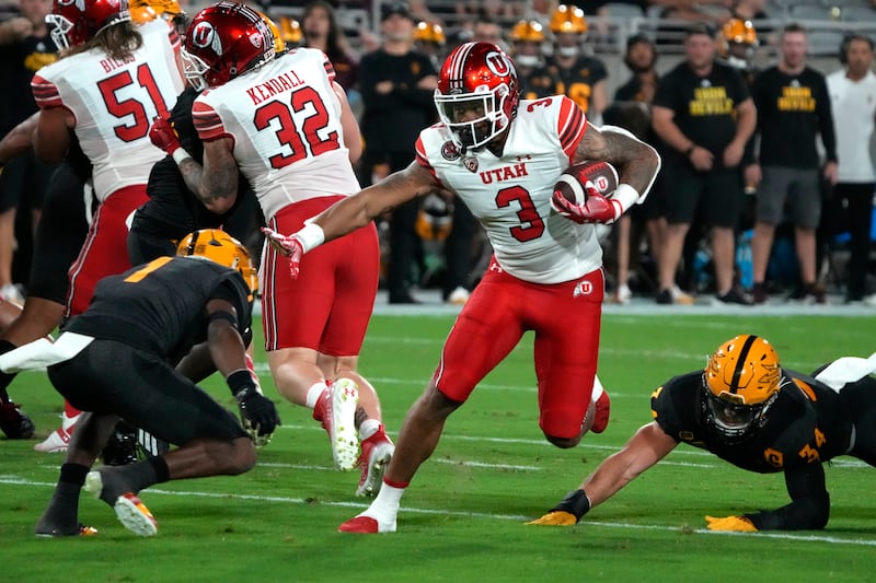 Utah quarterback Ja’Quinden Jackson (wearing white) during the second half of an NCAA college football game against Arizona State, Saturday, Sept. 24, 2022, in Tempe, Ariz.