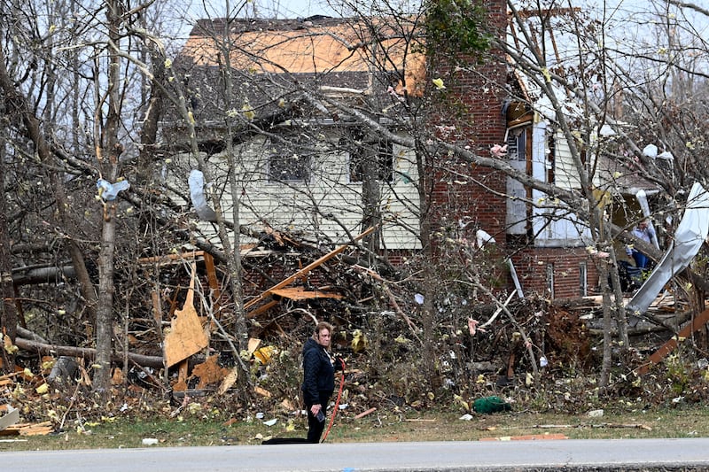 Toni Jackson is overcome with emotion as she walks her dog past damaged homes, Sunday, Dec. 10, 2023, in Clarksville, Tenn. Tornadoes caused catastrophic damage in Middle Tennessee on Saturday afternoon and evening, Dec. 9.