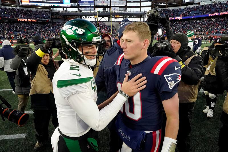 New York Jets quarterback Zach Wilson, left, greets New England Patriots quarterback Mac Jones, right, on the field following a game, Sunday, Nov. 20, 2022.