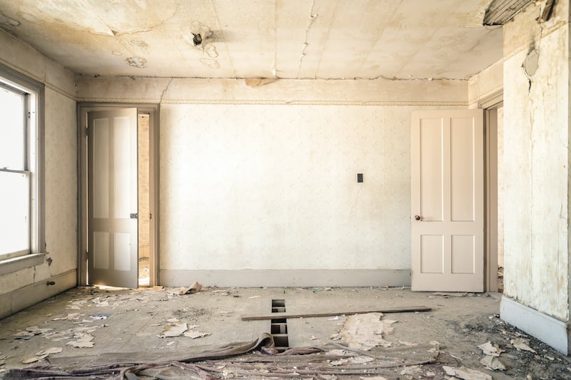 An empty room in a house with rubble around.