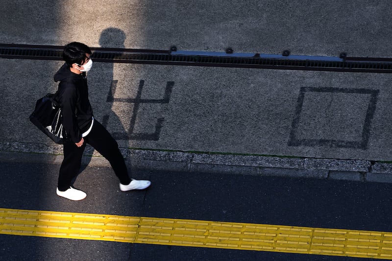 A man with a protective mask walks near an exit of a gas station at a usually crowded street in Tokyo Friday, April 17, 2020, in Tokyo. Japan’s Prime Minister Shinzo Abe has expanded a state of emergency to all of Japan from just Tokyo and other urban areas as the virus continues to spread. Japanese word read as “Exit.” (AP Photo/Eugene Hoshiko)