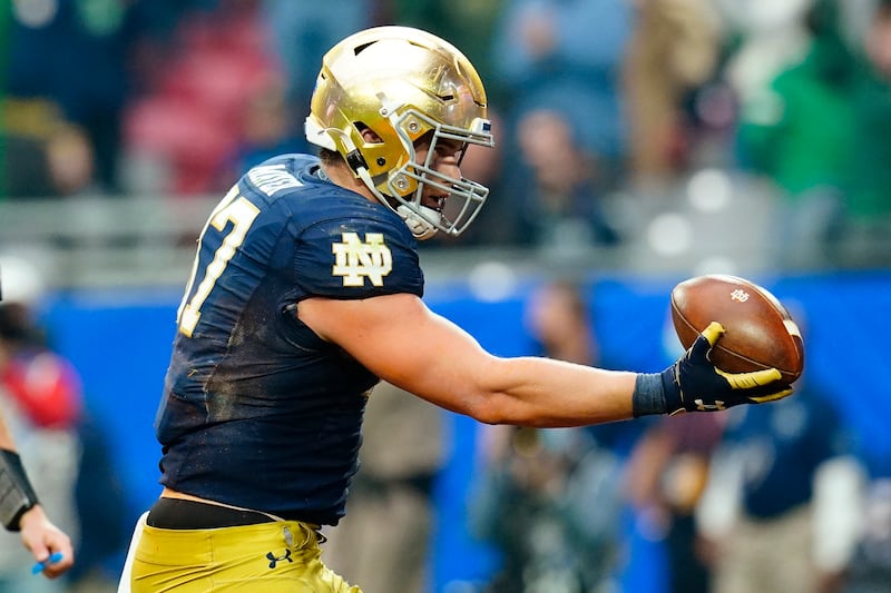 Notre Dame tight end Michael Mayer holds out a football to celebrate a touchdown.