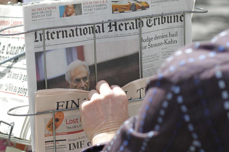 A man looks newspapers headlining on IMF head arrest at a news stand in Paris, Tuesday May 17, 2011. Allegations of sexual assault in a New York hotel have torn France's presidential race asunder and savaged the reputation of the suave and self-assured Do