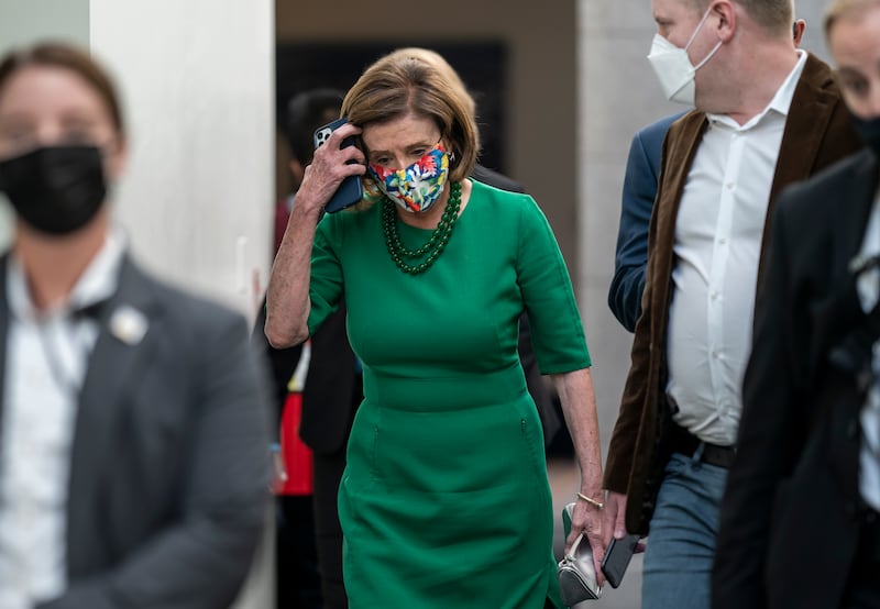Speaker of the House Nancy Pelosi, D-Calif., is accompanied by staff and security as she rushes to a Democratic Caucus meeting on Wednesday.