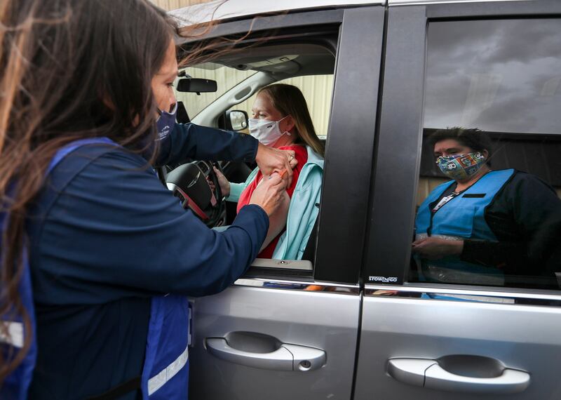 Tonya Hansen gives a flu shot during a drive-thru flu shot clinic.