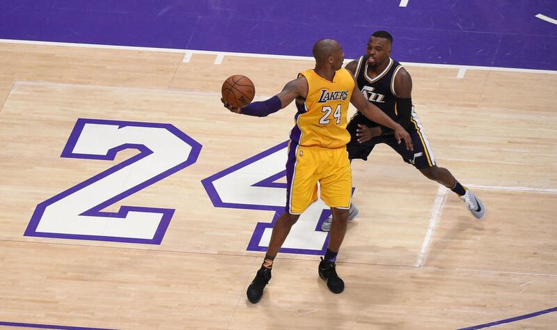 Los Angeles Lakers forward Kobe Bryant, left, works against Utah Jazz guard Shelvin Mack during the first half of an NBA basketball game, Wednesday, April 13, 2016, in Los Angeles.