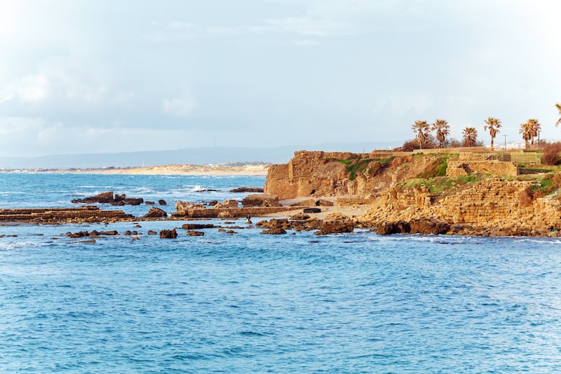 Sea coast and ruins of Caesarea Maritima before sunset in Israel.