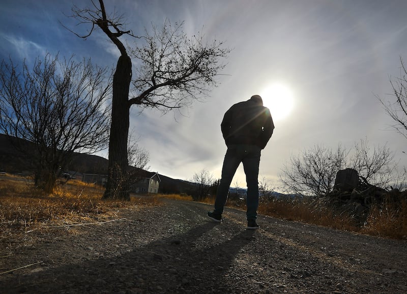 Governor of Utah, Spencer Cox, walks a dirt road with his back to the camera on his farm in Fairview, Sanpete County, Utah.