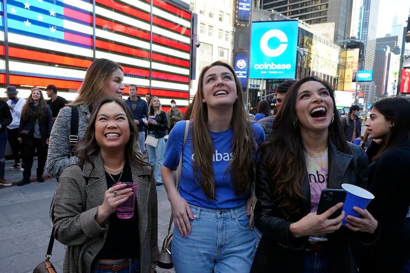 Coinbase employees celebrate outside the Nasdaq MarketSite, in New York’s Times Square, Wednesday, April 14, 2021. Wall Street will be focused on Coinbase Wednesday with the digital currency exchange becoming a publicly traded company.