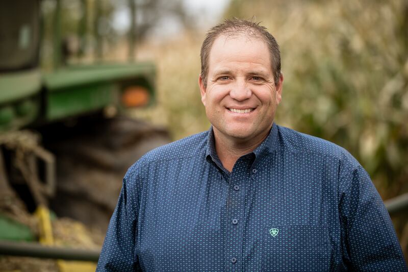 Ron Gibson stands with his farm in the background.