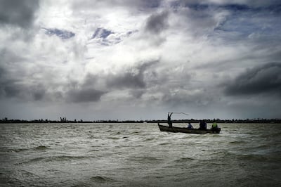 A fishermen beats the water to scare fish into the net in Tonga on Thursday, May 23, 2019.
