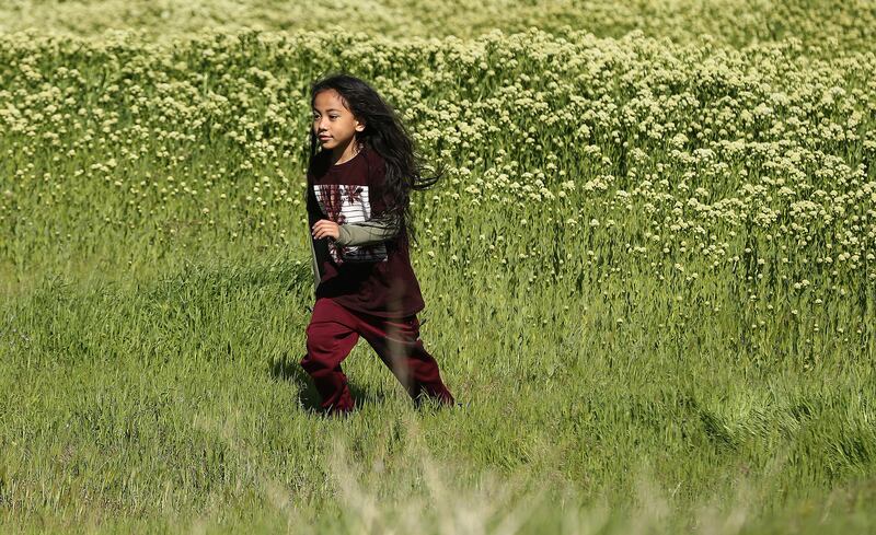 Tangata' Olakepa Tavai runs through a field during a May Day event aimed at fighting the Utah Inland Port project in Salt Lake City on Wednesday, May 1, 2019. The event was sponsored by the Stop the Polluting Port Coalition, which is composed of nonprofit