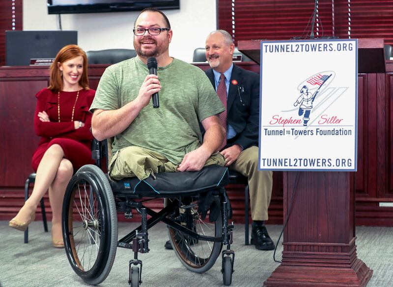 Jennie Taylor, widow of North Ogden Mayor Maj. Brent Taylor, left, and Frank Siller, chairman and CEO of Stephen Siller Tunnel to Towers Foundation, listen as Army Sgt. 1st Class Travis Vendela, talks about his physical struggles living in his current hom