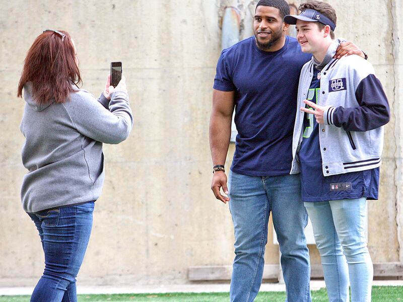 Former Utah State and current Seattle Seahawks linebacker Bobby Wagner poses for a photo with young Aggie/Seahawk fan during Saturday's Blue vs. White Spring Game in Logan.