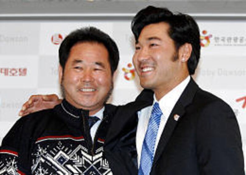 Olympic medalist Toby Dawson, right, beams with his biological father, Kim Jae-Su, during a reunion in Seoul, South Korea, Wednesday.