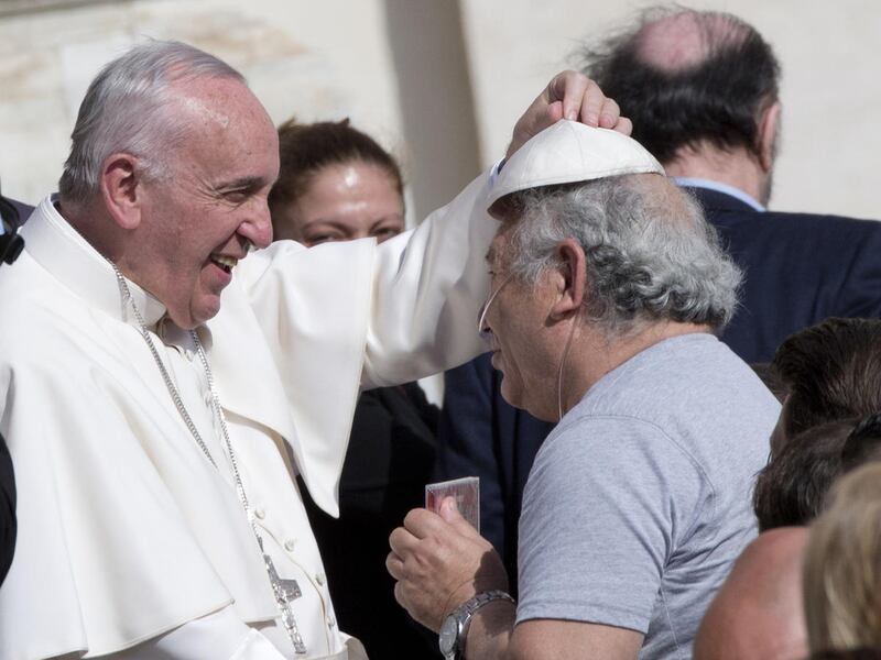 Pope Francis jokes with his skull cap with Salvatore Sessa, a musician from Prato, Italy, at the end of his weekly general audience in St. Peter's Square at the Vatican, Wednesday, Oct. 7, 2015. (AP Photo/Alessandra Tarantino)