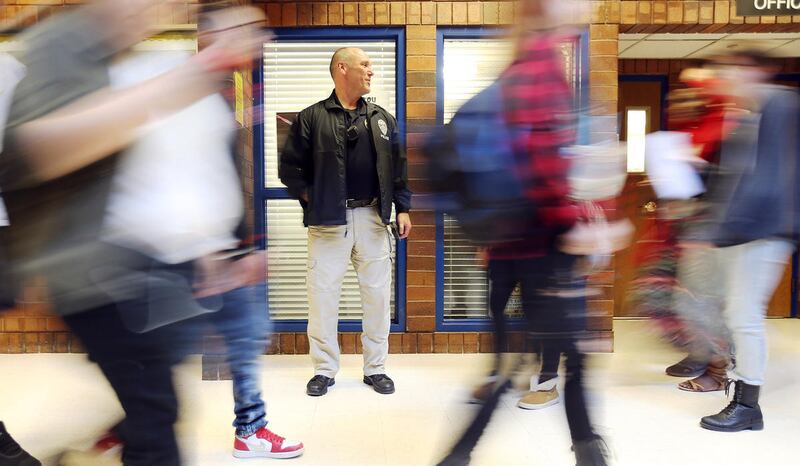 FILE - Unified police detective Jerry Byam stands in a hallway as school ends for the day at Taylorsville High on Monday, March 13, 2017. According to Utah school and police officials, sexting is so widespread that many teens just accept it as commonplace
