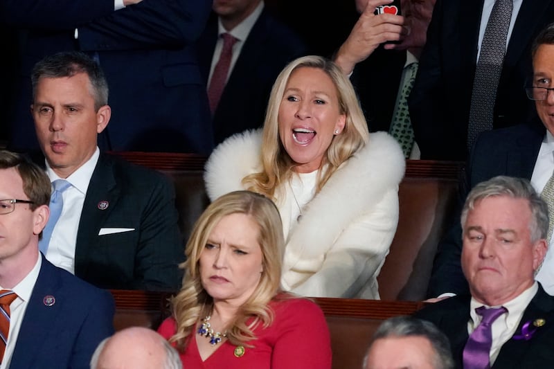 Rep. Marjorie Taylor Greene, R-Ga., center, listens and reacts as President Joe Biden delivers his State of the Union speech.