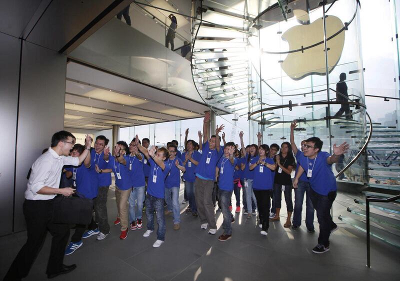 A customer cheers with staff members of Apple Inc. as the Apple store in Hong Kong started selling iPhone 5 Friday, Sept. 21, 2012. Apple's Asian fans jammed the tech juggernaut's shops in Australia, Hong Kong, Japan and Singapore to pick up the latest v