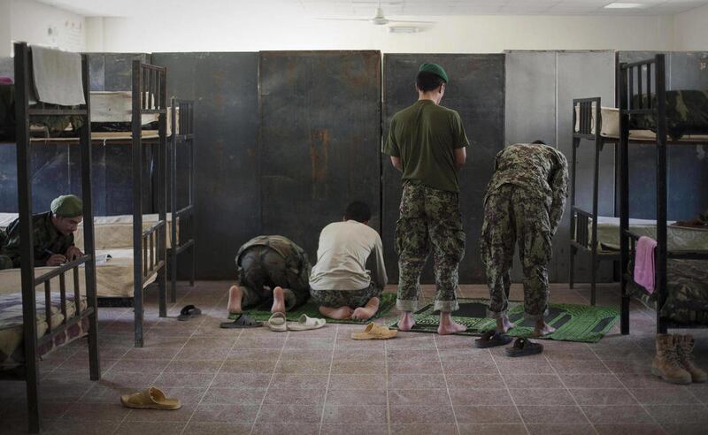 Afghan National Army soldiers pray inside their sleeping quarters at their barracks in Kunduz, northen Afghanistan, Sunday,Sept. 25, 2011.