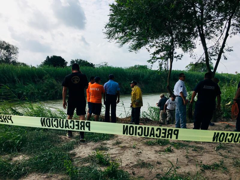 FILE - Authorities stand behind yellow warning tape along the Rio Grande bank where the bodies of Salvadoran migrant Oscar Alberto Martínez Ramírez and his nearly 2-year-old daughter Valeria were found, in Matamoros, Mexico, Monday, June 24, 2019, after t