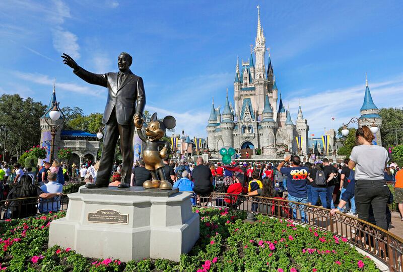 Bronze statue of Walt Disney and Micky Mouse in front of the Cinderella Castle at the Magic Kingdom.