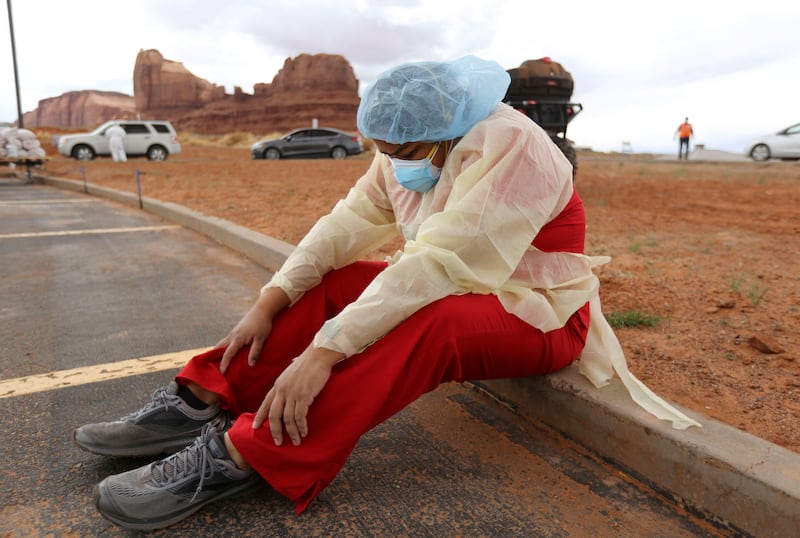 Denise Begaye, an X-ray technician with the Monument Valley Health Center, sits on a curb and takes a break from COVID-19 testing in Oljato-Monument Valley, San Juan County on April 16, 2020.