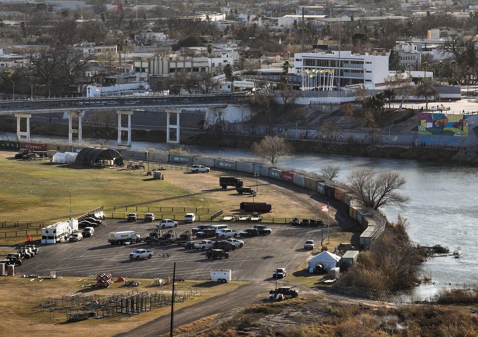 Shipping containers and concertina wire line the banks of the Rio Grande, in Shelby Park in Eagle Pass, Texas.
