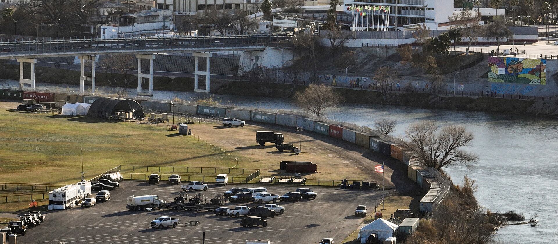 Shipping containers and concertina wire line the banks of the Rio Grande, in Shelby Park in Eagle Pass, Texas.