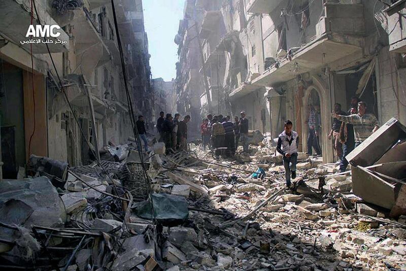 This Wednesday, March. 19, 2014 photo provided by the anti-government activist group Aleppo Media Center (AMC), which has been authenticated based on its contents and other AP reporting, Syrians inspect the rubble of destroyed buildings following a Syrian