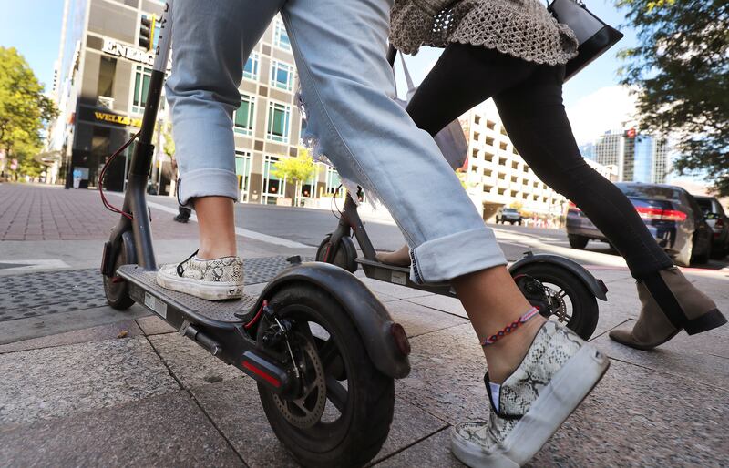People ride Bird scooters on Main Street in Salt Lake City on Friday, Oct. 5, 2018. Bird Rides Inc. announced plans to upgrade its current fleet of electric scooters with new models.