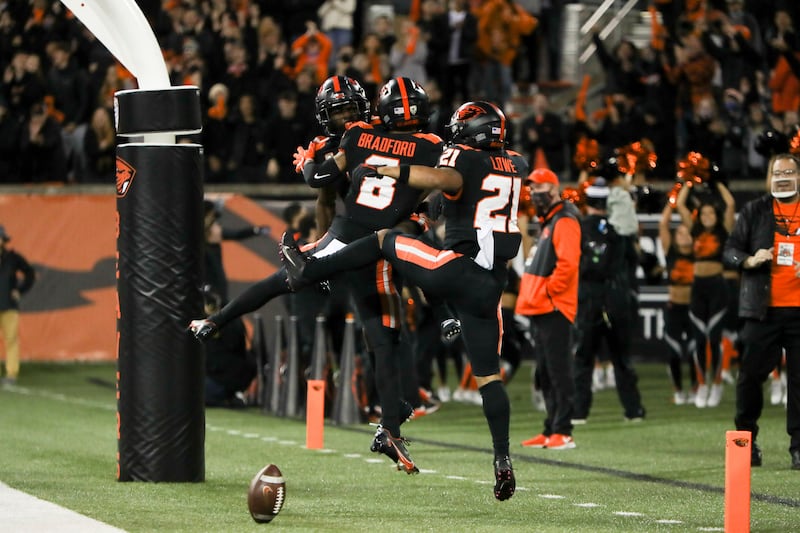 Oregon State’s Tyjon Lindsey, Trevon Bradford, and Trey Lowe jump in the end zone to celebrate Bradford’s touchdown
