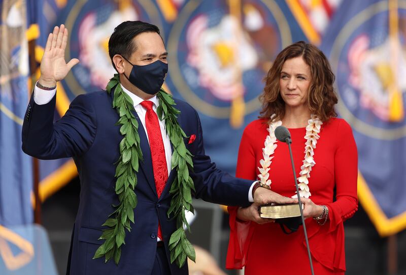 Sean Reyes, Utah Attorney General, lays his hand on the Bible held by his wife, Saysha, to take his oath of office.