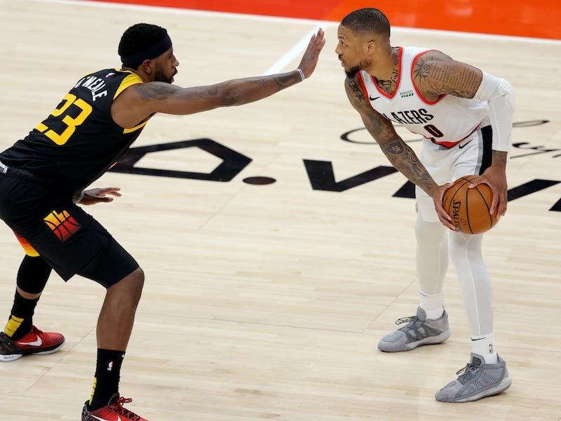 Utah Jazz forward Royce O’Neale (23) sticks his hand in front of Portland Trail Blazers guard Damian Lillard (0)