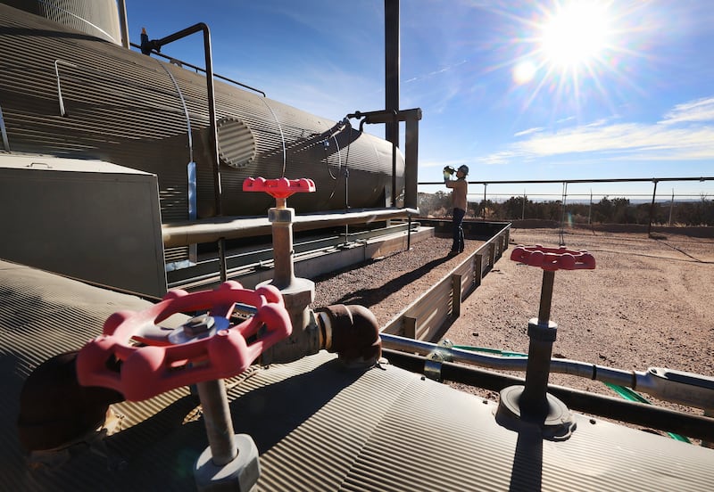 Stephen Foulger, of the Utah Department of Environmental Quality, inspects an oil pump site.