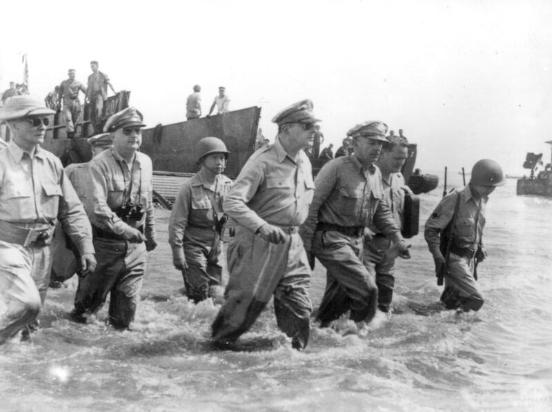 In this photo provided by the U.S. Army, Gen. Douglas MacArthur, center, is accompanied by his officers and Sergio Osmena, president of the Philippines in exile, extreme left, as he wades ashore during landing operations at Leyte, Philippines, October 20,
