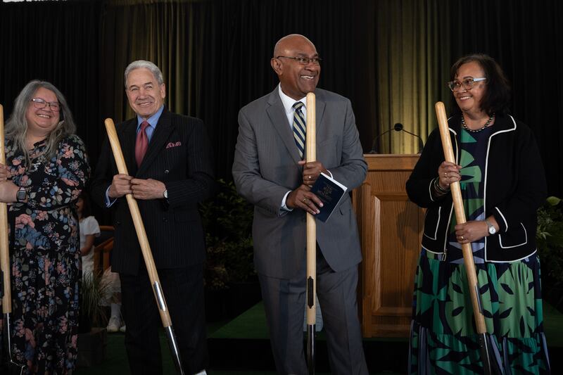 Four people holding ceremonial shovels into the ground.