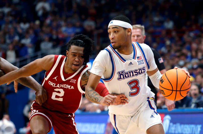 Kansas guard Dajuan Harris Jr. (3) attempts to get past Oklahoma guard Javian McCollum (2) during the first half of an NCAA college basketball game, Saturday, Jan. 13, 2024, in Lawrence, Kan.