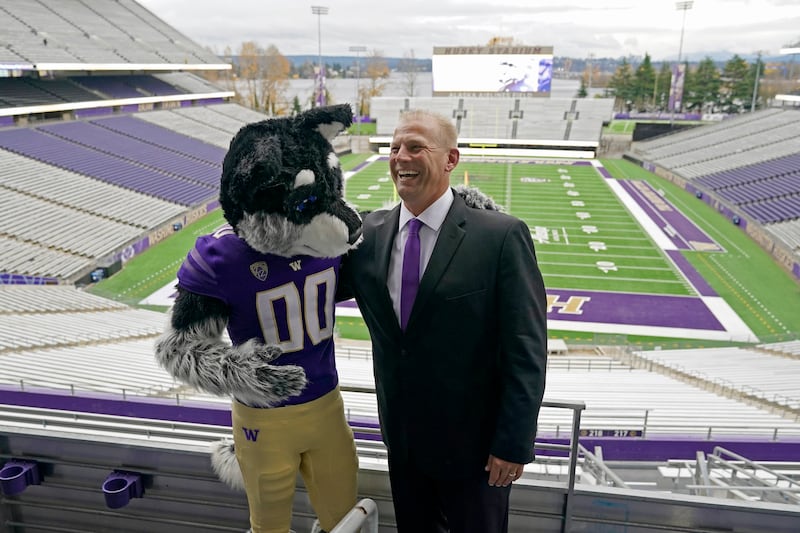 Kalen DeBoer reacts as he poses for photo with Harry, the Washington mascot, Tuesday, Nov. 30, 2021, at Husky Stadium in Seattle.