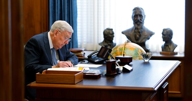 President M. Russell Ballard works in his office with sculptures of his ancestors positioned nearby.