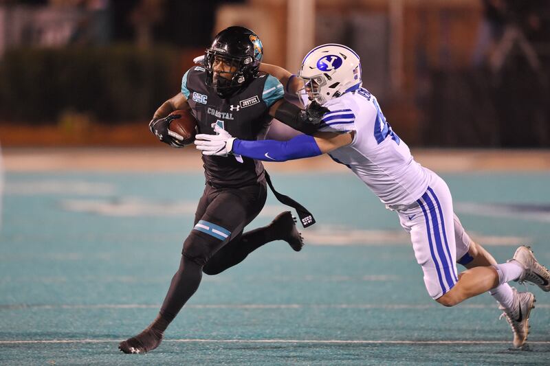 Coastal Carolina’s CJ Marabale rushes while defended by BYU’s Drew Jensen during the first half of an NCAA college football game Saturday, Dec. 5, 2020, in Conway, S.C. Coastal Carolina won 22-17. (AP Photo/Richard Shiro)