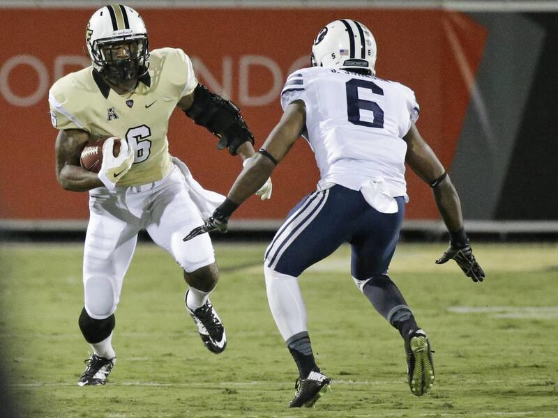 Central Florida wide receiver Rannell Hall, left, runs with the ball as Brigham Young defensive back Jordan Johnson tries to stop him during the first half of an NCAA college football game in Orlando, Fla., Thursday, Oct. 9, 2014. (AP Photo/John Raoux)